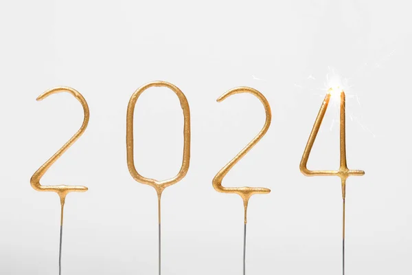 Altın sayılar 2024 ve gri izole arka planda yanan 4 numaralı maytap. Yeni yılı kutlamak, eskisini bitirmek, selamlar ve dilekler.