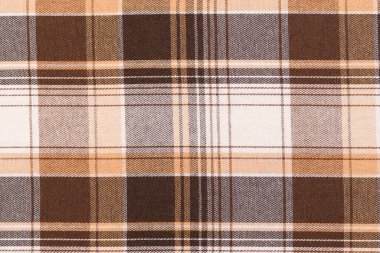 Kahverengi ve fildişinin yakın çekim dokusu tartan kumaşı kontrol etti. Geleneksel İskoç kıyafetleri. Gömlek ve etek yapmak için malzeme