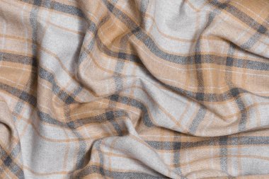 Bej ve gri taratan renginde buruşmuş sıcak kumaş dokusu. Geleneksel İskoç kıyafetleri. Tasarımın için resim