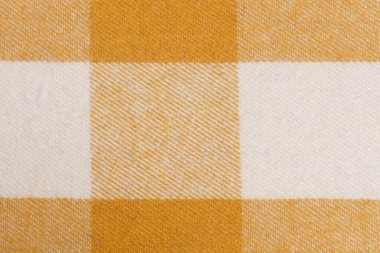 Bir tartan hücresinde sıcak sarı renkli kumaşın yakın çekim dokusu. Elbise dikmek için malzeme konsepti. Geleneksel İskoç tasarımı