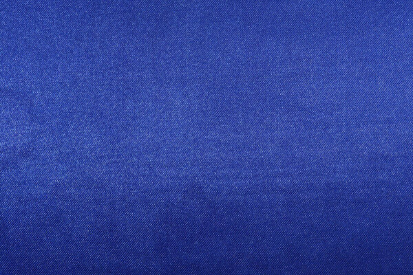 texture of deep blue fabric with glare close-up. background for your design. material for sewing festive costumes, toys and clothes