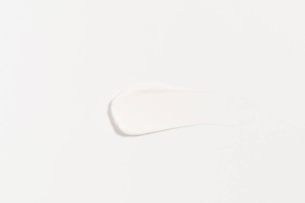 texture of a white smear of cream on an isolated background. concept of beauty products for moisturizing and skin care