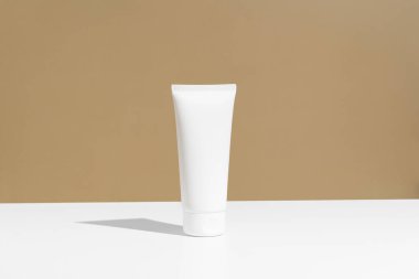 Bej arka planda beyaz krem tüp modeli. Kozmetik, vücut ve yüz bakımı kavramı. Tasarımın için resim.