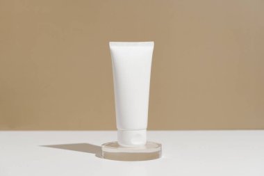 Beyaz krema kavanozu ya da bej arka plandaki kaideye sürülmüş losyon. Doğal günlük bakım kozmetik konsepti.