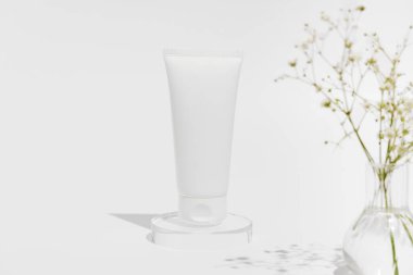 Vazoda bitki bulunan beyaz arka planda beyaz tüp modeli. Doğal kozmetik ürünleri, cilt bakımı konsepti