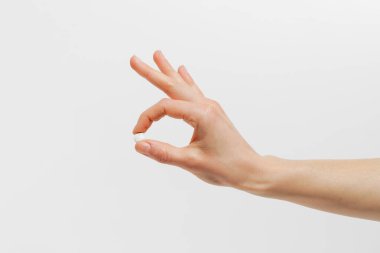 Beyaz yalıtılmış arka planda sarı şeffaf hap kapsülü tutan kadın el. Sağlık, eczane ve beslenme takviyeleri kavramı.