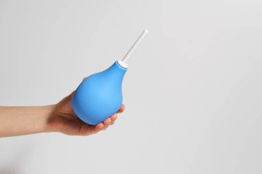 Beyaz izole arka planda mavi kauçuk lavmana basan kadın eli. İlaç ürünleri kavramı, tıbbi prosedürler, sağlık.