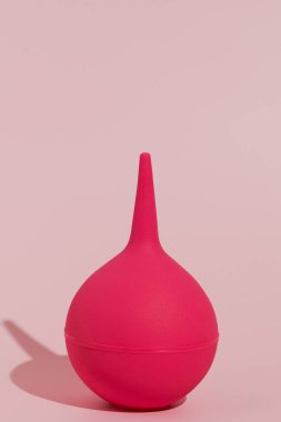 Pembe izole edilmiş arka planda pembe kauçuk lavmanın dikey görüntüsü. Vücudu temizleme ve detoksifikasyon konsepti, tıbbi ve ilaç ürünleri. Tasarımın için resim