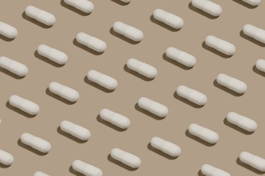 Bej izole arka planda beyaz hap kapsülleri deseni. İlaç, vitamin ve sağlık takviyesi kavramları. Tasarımın için resim