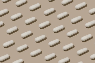 Bej izole arka planda beyaz kapsül hapları var. Eczane, ilaç, vitamin ve besin takviyesi kavramı. Tasarımın için resim