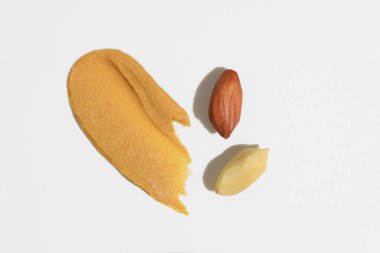 Fıstık ezmesinin fırça dokusu ve beyaz yalıtılmış arka planda fındıklar. Kahvaltı ve atıştırmalıklar için doğal gıda ürünleri, protein kaynakları