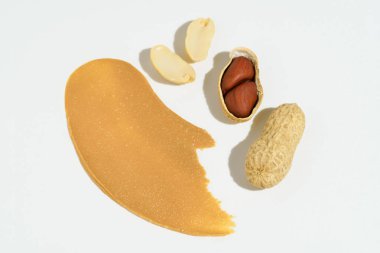 Beyaz izole arka planda kahverengi fıstık ezmesi ve kabuklu fıstık kokusu. Sağlıklı atıştırmalıklar, protein kahvaltıları.