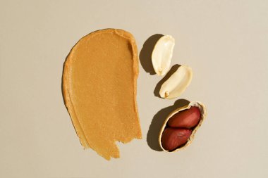 Fıstık ezmesi ve bej izole arka planda fıstık ezmesi. Protein kaynağı, sağlıklı atıştırmalık, fındık ezmesi konsepti..