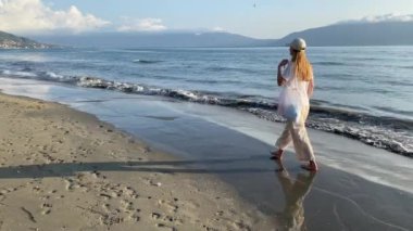 Heteroseksüel pantolonlu, beyaz tişörtlü genç bir kadının kumsalda rüyasında yürüdüğünü gördüm. Yalnız zaman geçirme kavramı, doğayla bütünlük, gerçek insanların yaşam tarzı.