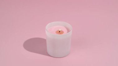 Pembe izole arka planda yanan fitili olan pembe mum yakın plan. Samimiyet, ev ve iç dekorasyon, kutlama, meditasyon ve rahatlama konsepti