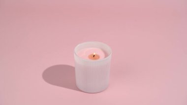 Camda pembe soya mumu ve pembe izole edilmiş arka planda yanan fitil. Samimiyet, dekorasyon, kutlama, meditasyon ve rahatlama kavramı.