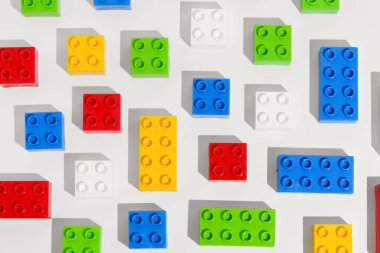 Beyaz izole edilmiş arka planda yapılar inşa etmek için birçok kare plastik renkli gökkuşağı tuğla bloklarının üst görüntüsü. Eğitim oyunları konsepti. Tasarımın için resim