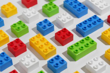 Gökkuşağı renkli yapı taşları beyaz izole arkaplanda oyuncak tuğlalar. Eğitim oyunları konsepti