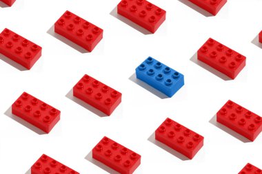 İnşaat için kırmızı dikdörtgen tuğla kalıpları ve beyaz izole arka planda mavi antagonist. Yüzleşme ve muhalefet kavramı, kalabalıktan uzak durmak. Eğitim Oyunları