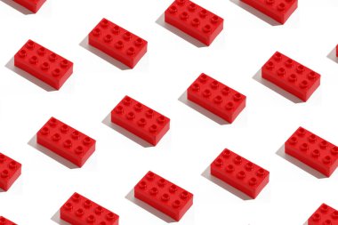Birçok dikdörtgen kırmızı plastik yapı taşı kalıbı beyaz izole arka plandaki inşaatçılar için oyuncak tuğlalar. Çocukların eğitim oyunları konsepti.