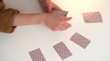 Sarı tişörtlü genç bir kadın masa oyunu için klasik kart dağıtıyor. Oyun konsepti, eğlence, eğlence, poker, solitaire.