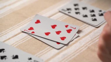 Masada solitaire oynarken genç bir kadının el falına bakıp kart istiflemesi. Eğlence konsepti, eğlence, kart oyunları, poker