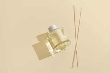 Aroma sazlık, ev için temiz cam şişe ve bej izole arkaplanda rattan çubuklar. Dekorasyon, higge ve aromaterapi konsepti. Ev için tütsü çubukları. Tasarımın için resim
