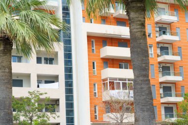 Arnavutluk 'ta deniz kıyısı yakınlarında palmiye ağaçları bulunan Akdeniz tarzı modern minimalist apartmanlar. Yabancı gayrimenkul kavramı, dijital göçebeler, tatil köyündeki kiralık daireler.