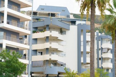 Arnavutluk 'ta deniz kıyısı yakınlarında palmiye ağaçları bulunan Akdeniz tarzı modern minimalist apartmanlar. Yabancı gayrimenkul kavramı, dijital göçebeler, tatil köyündeki kiralık daireler.