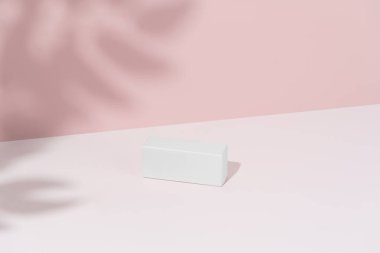 Pembe arka planda beyaz bir model kutusu ve bir dalın gölgesi. Yeni bir ürünün markalı ambalajı, sunumu ve reklamı. Tasarım şablonu