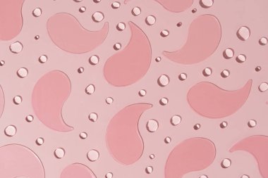 Pembe, desenli arka plana yerleştirilmiş pembe hidrojel yamalar. Bu göz altı bantları hassas cildi nemlendirmek ve canlandırmak için idealdir. Güzellik rutini, siyah halkaları çıkarmak için..