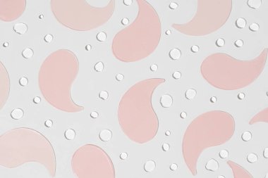 Su jeli pembe göz bantları ve beyaz arka planda damlalar var. Göz altı derisini nemlendirmek ve beslemek için ideal bir güzellik ürünü, cilt bakımı için taze, canlandırıcı bir element eklemek,.