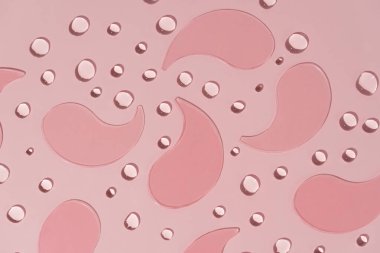 Pembe desenli hidrojel göz bantlarının yakın plan resmi. Pembe arka planda yumuşak damlalar var. Göz altı derisini nemlendirir ve canlandırır. Koyu halkaları ve kırışıklıkları yok eder.