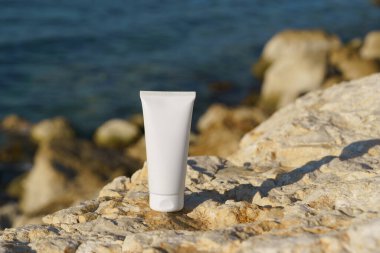 Beyaz yüz kremi tüpü ya da taşlarla kaplanmış vücut kremi. Güneş kremi, vücut koruma ve su, krem ve losyon kavramı