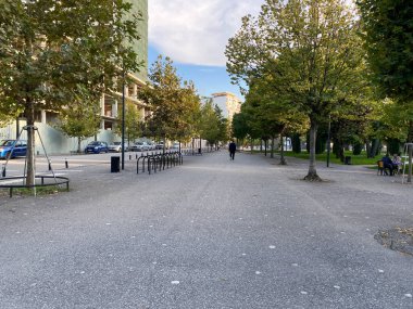 Arnavutluk 'un Vlora kenti - 16 Ocak 2025: Evleri, yeşil santralleri ve arabaları olan küçük bir Arnavut kasabasında Paved yolu. Arkaplan, seyahat yazıları veya dizayn şablonları için ideal.