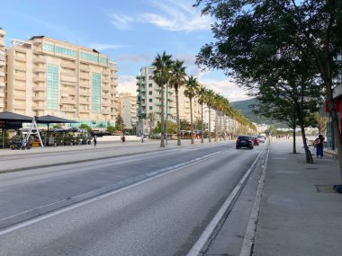 Arnavutluk 'un Vlora kenti - 16 Ocak 2025: Mimari ve yeşil bitkileri olan büyüleyici bir Arnavut caddesi. Bu temiz, barışçıl ortam, yerel yaşam ve turizm hakkındaki makalelere uyuyor.