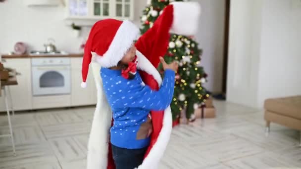 Uma Menina Afro Americana Coloca Enorme Traje Papai Noel Contra — Vídeo de Stock