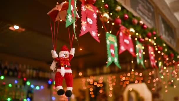クリスマスライトと装飾を背景にパラシュートでおもちゃの雪だるま — ストック動画