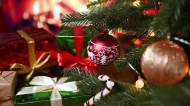 Noel oyuncakları ve yeni yıl hediyelerini yanan şöminenin arka planına ve Noel ağacına karşı yakın plan çekimde.