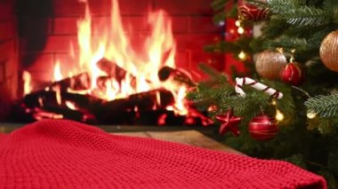 Süslü bir Noel ağacının arka planına yakın kırmızı ekose örülmüş ve şömine yakılmış..