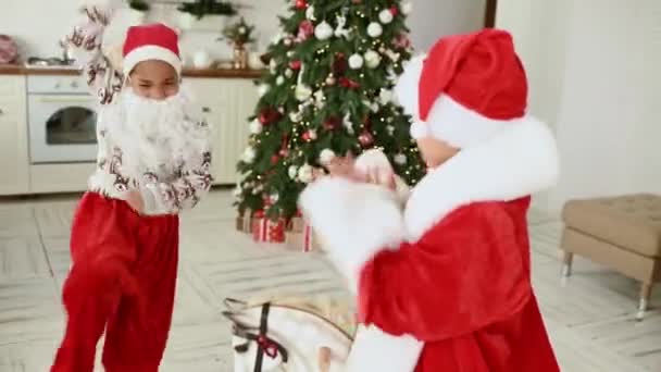 Мальчик Девочка Веселятся Танцуют Фоне Рождественской Елки Одетой Санта Клаус — стоковое видео