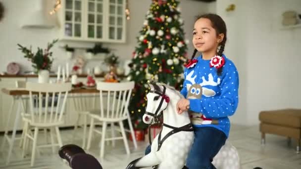 Una Niña Afroamericana Suéter Azul Navidad Sonríe Mientras Está Sentada — Vídeos de Stock
