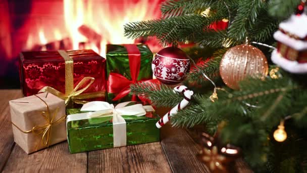 クリスマスツリーや暖炉を背景に木製のテーブルの上にクリスマスプレゼント付きの箱がたくさんあります — ストック動画