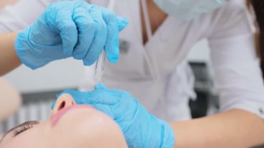 cosmetic procedure gas-liquid peeling - rejuvenation and regeneration of the skin using a jet consisting of oxygen and liquid. The cosmetologist holds an applicator with oxygen and carbon dioxide in