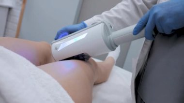 Correction of the figure and body shape. Close-up of the device massaging the buttocks and legs of a young woman. The concept of beauty and body care. The cosmetologist uses the device for endospheric