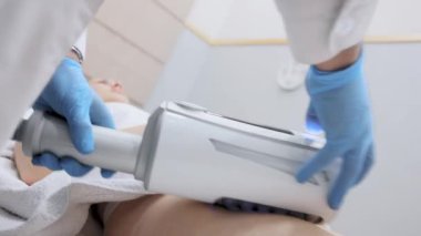 Correction of the figure and body shape. Close-up of the device massaging the buttocks and legs of a young woman. The concept of beauty and body care. The cosmetologist uses the device for endospheric