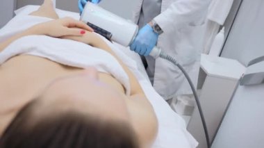 Correction of the figure and body shape. Close-up of the device massaging the buttocks and legs of a young woman. The concept of beauty and body care. The cosmetologist uses the device for endospheric