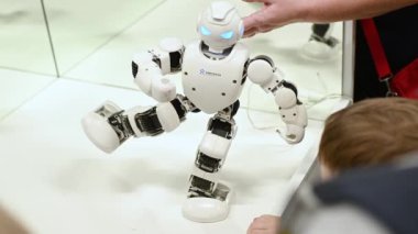 Rostov-on-Don, Russian Federation - December 27, 2022. Children watch a dancing robot at a robotics exhibition.