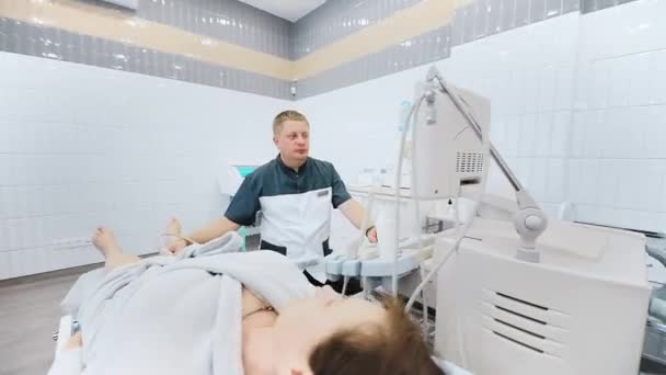 医者は患者の足の静脈の超音波を行う 臨床医は現代の診療所で超音波装置で女性の足の静脈をチェックします — ストック動画