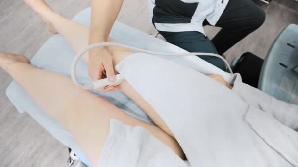 医者は患者の足の静脈の超音波を行う 臨床医は現代の診療所で超音波装置で女性の足の静脈をチェックします — ストック動画